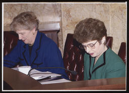 Mary Ann Dailey and Pat Vance look down at their desk in Ryan committee room
