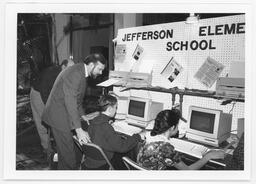 Rep. Donald Snyder looking over a student's shoulder at a computer screen during the Student Technology Showcase