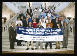 Rep. Paul Semmel stands with students on the Main Rotunda steps with the banner, "Pennsylvania Emergency Services Youth Leadership Challenge."